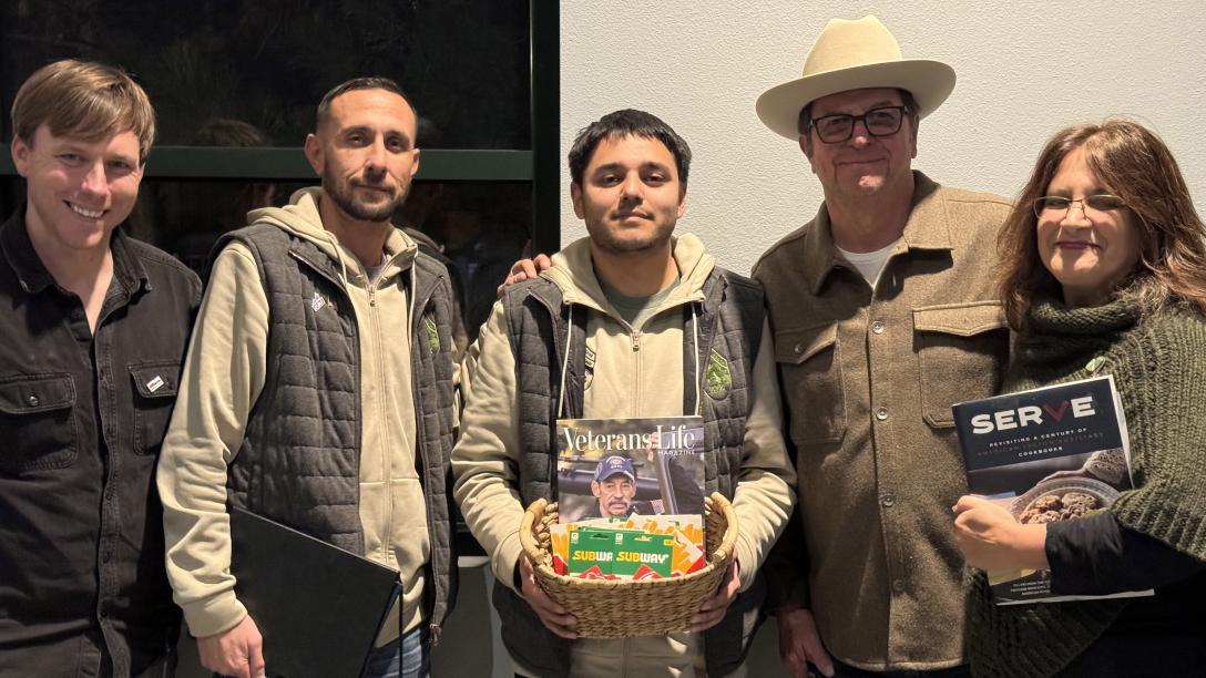 five people standing together one holding basket with books