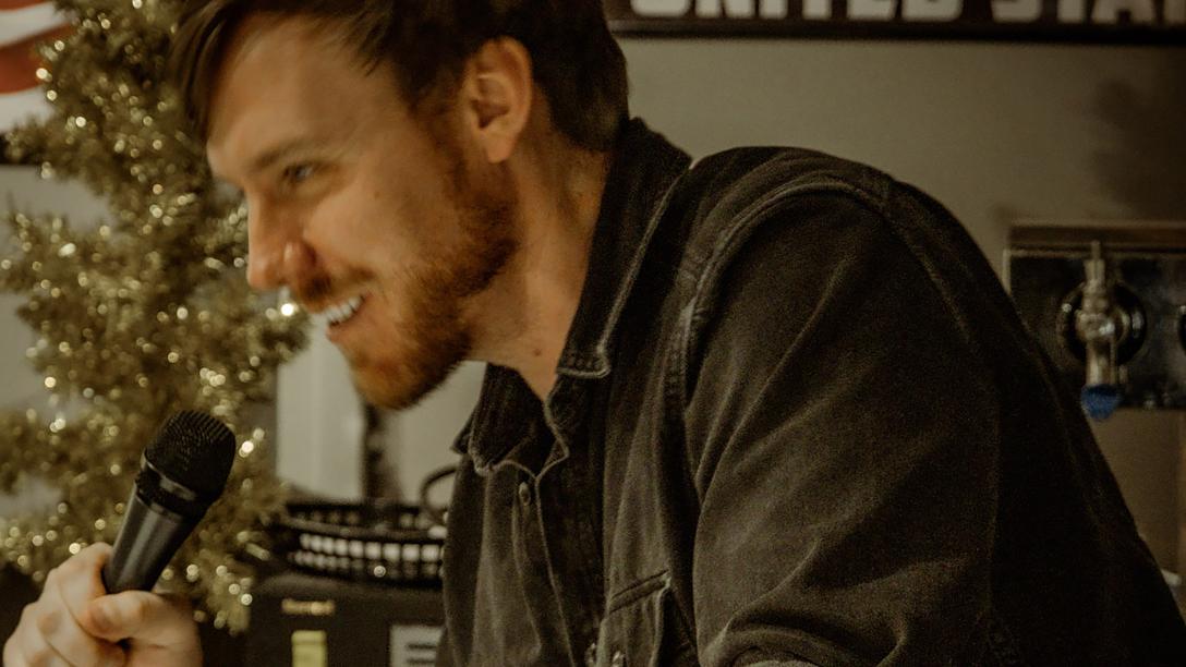 man smiling sideways to camera talking