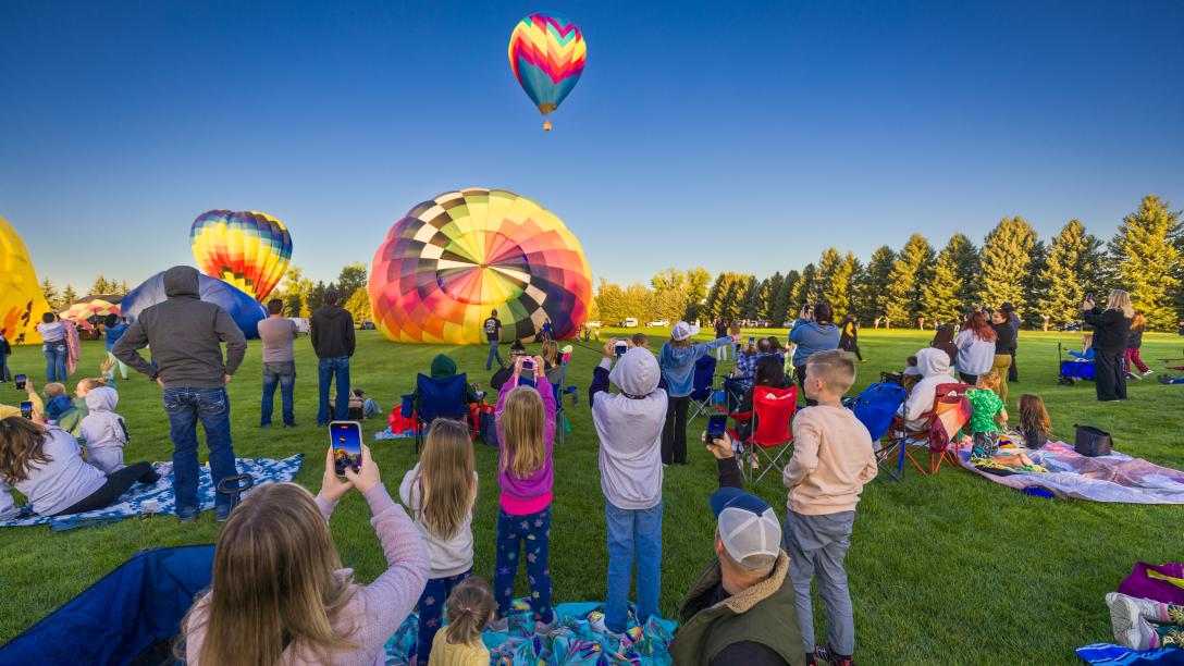 Crowd watching hot air balloons launching