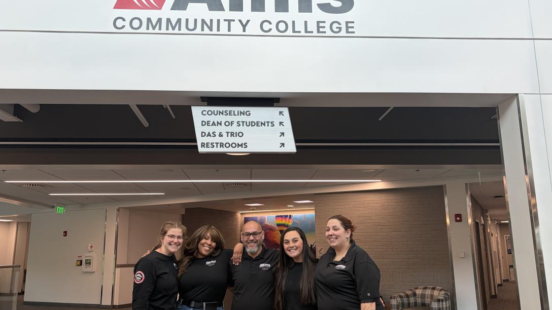 SGA posing under the Aims logo in the Student Commons building, second floor.