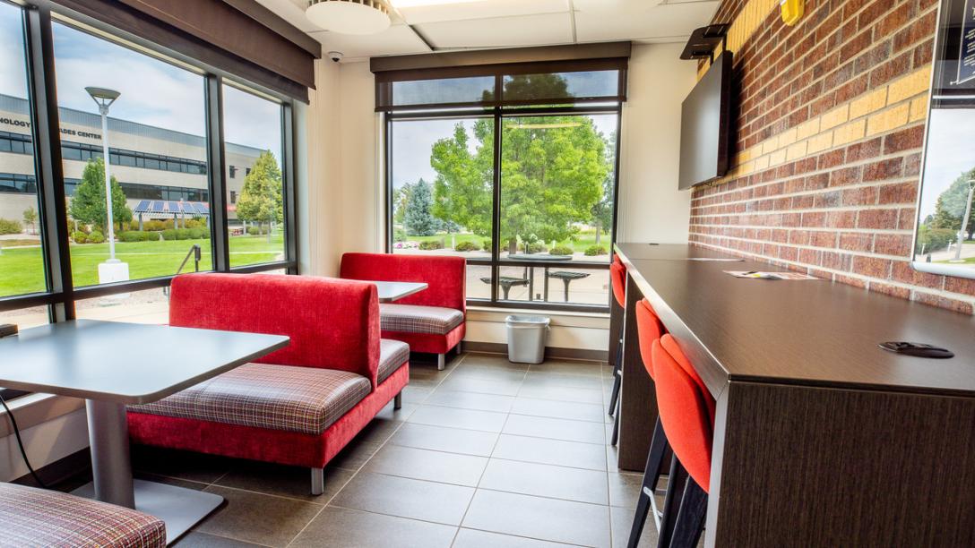 Summit Building student study space with red benches, chairs and tables near large windows