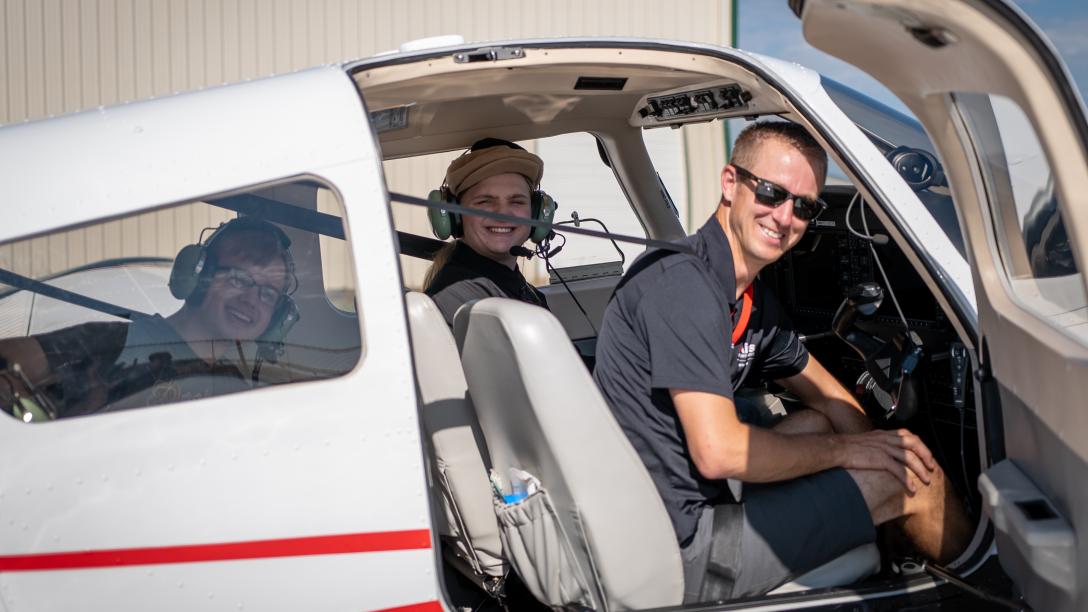 People smiling from Aims plane at Aviation Day