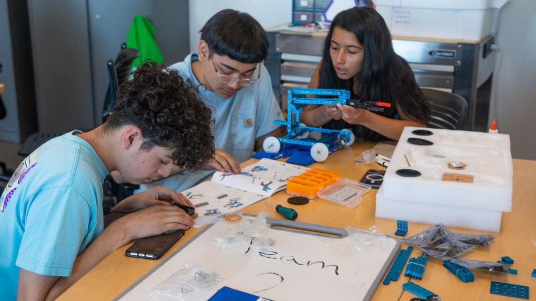 Students working on a project across the table.