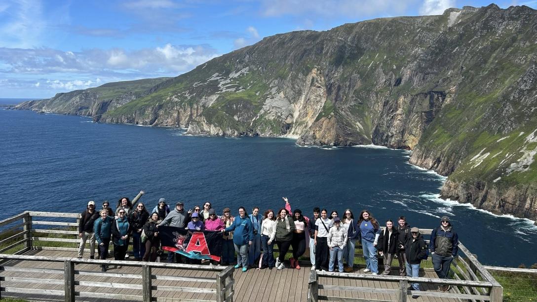 Study Abroad Group on Dock with water and hill