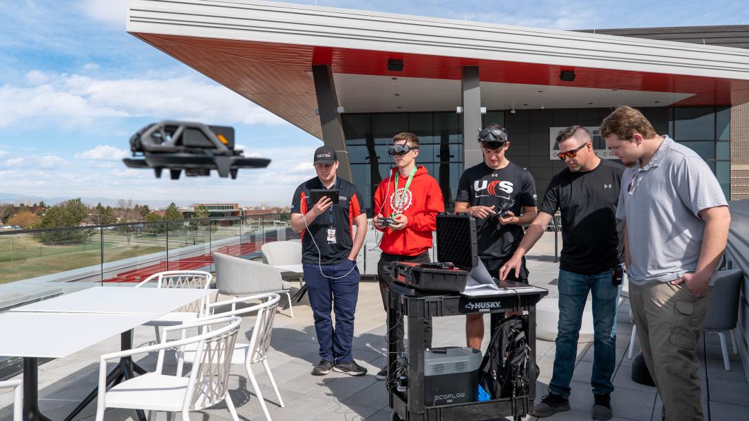 Aims UAS Students with flying drone on Welcome Center Patio