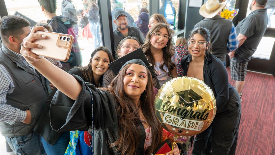 Selfie of Graduate with balloon and family and friends