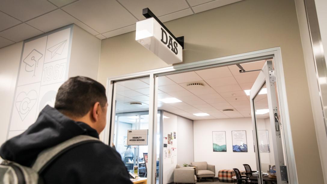 A student walking into the door of the Aims Disability Access Services Office