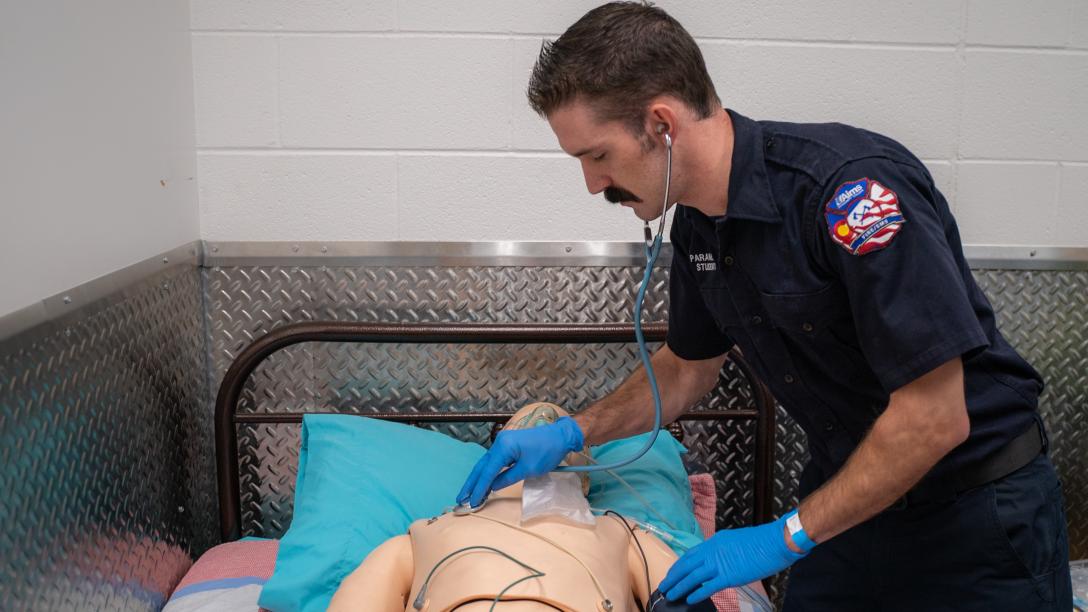 Man demonstrating basic life support on a manikin/CPR dummy