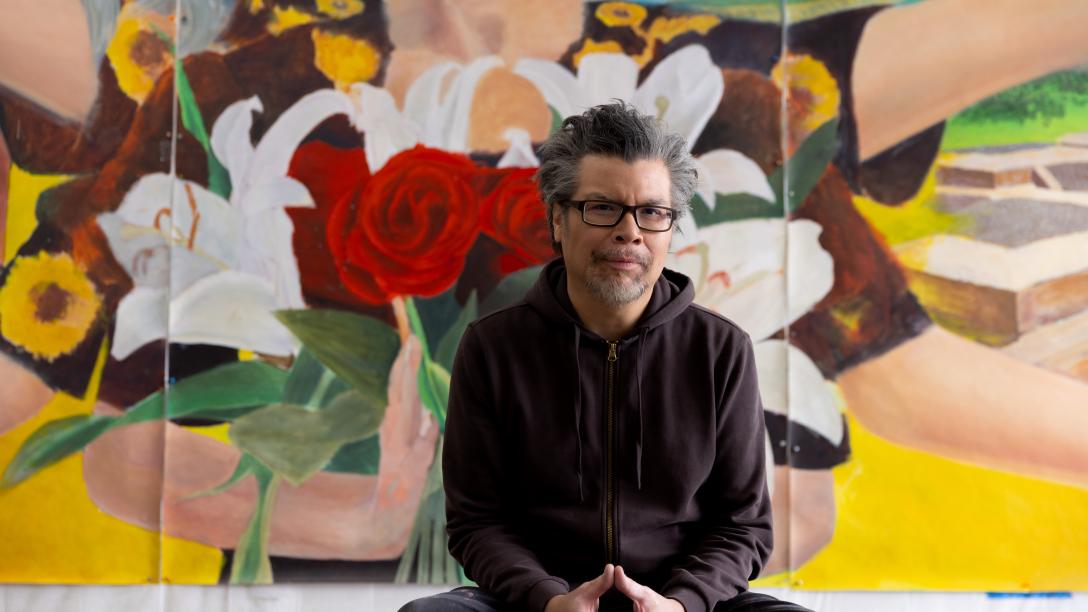 Frank Garza in front of his art