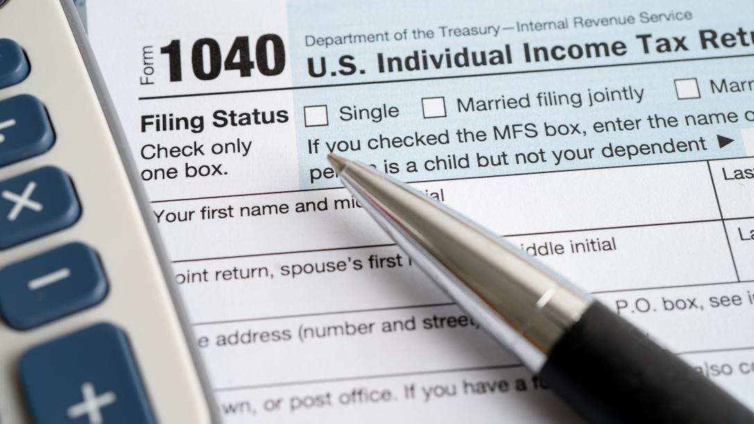 tax forms with pen and calculator
