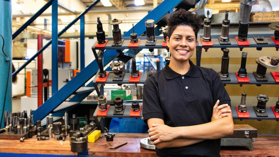 Person posing in front of tools and equipment