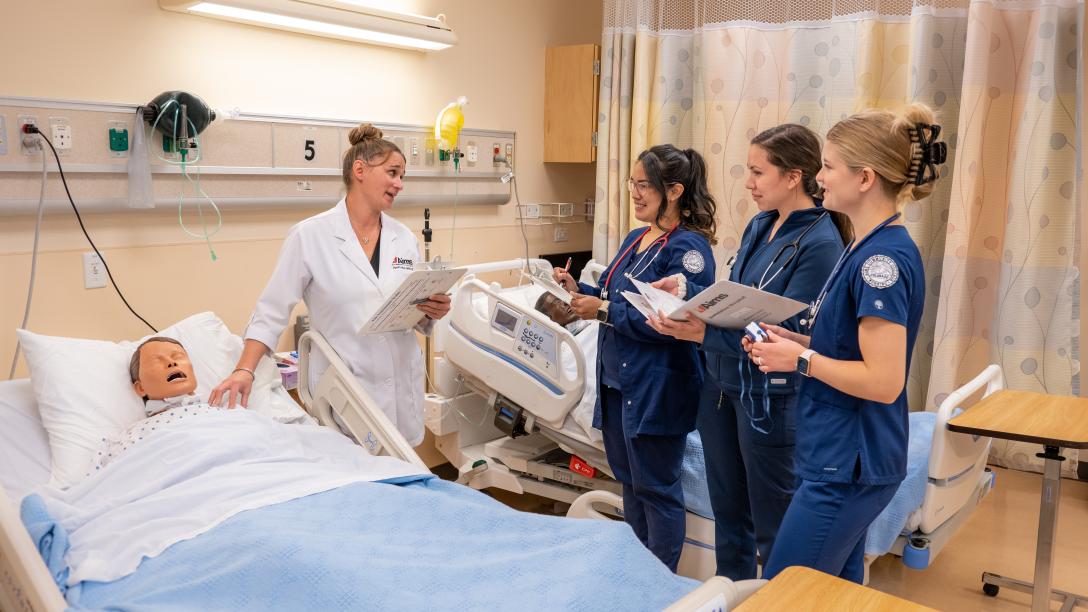 Nursing students and instructor in mock hosptial room