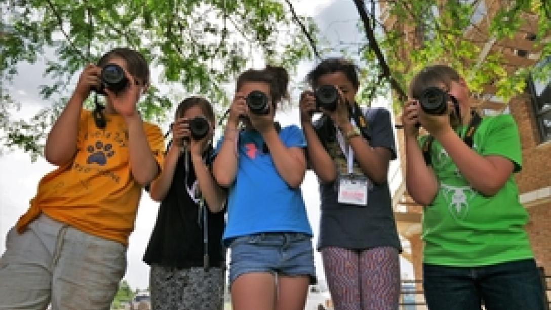 Five kids holding cameras facing lens