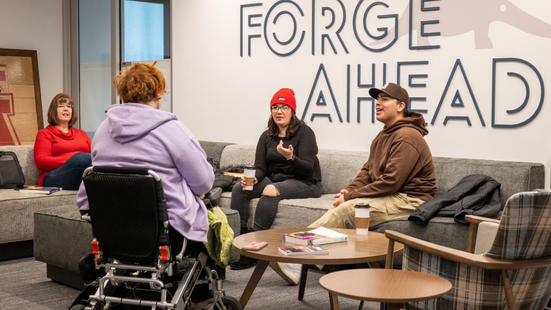 Students at the Student Commons Lobby with Forge Ahead art on the wall