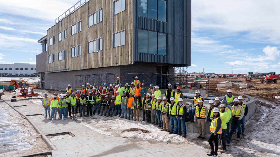 Construction crew at Aims Windsor Construction Site with building in background