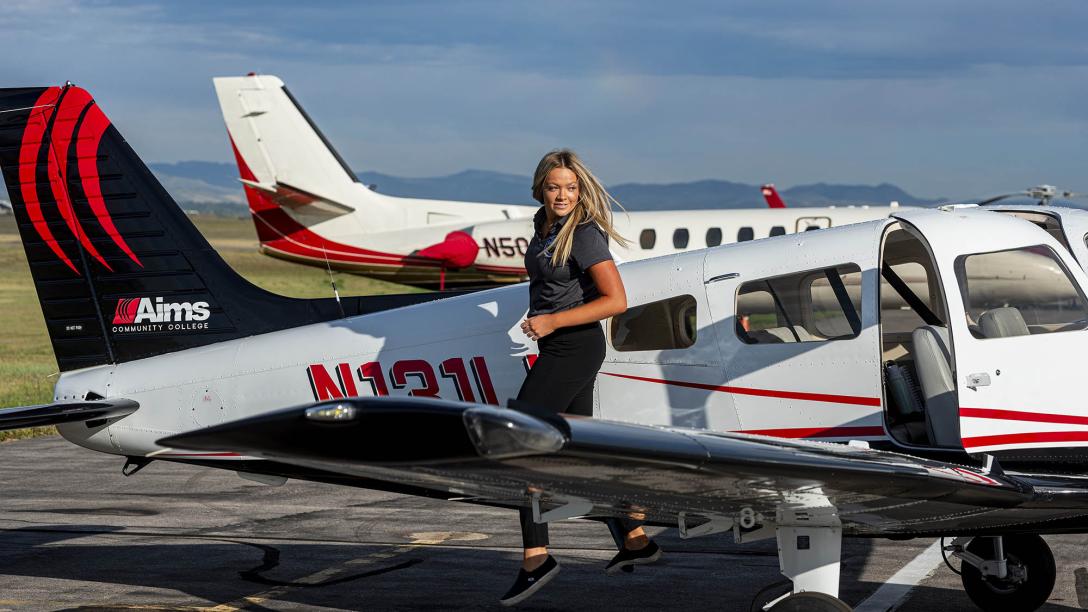 An aviation program student exits a plane on the tarmac at the Aims Community College flight school.