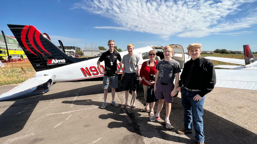 People standing in front of an Aims Airplane