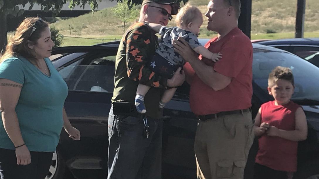Man handing baby to Province