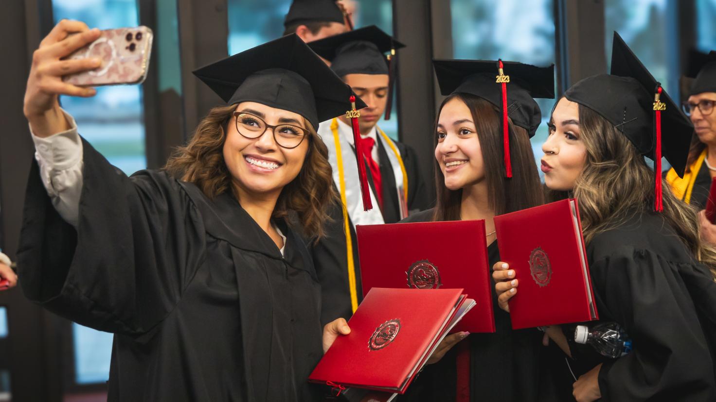 Aims students take a photo during commencement