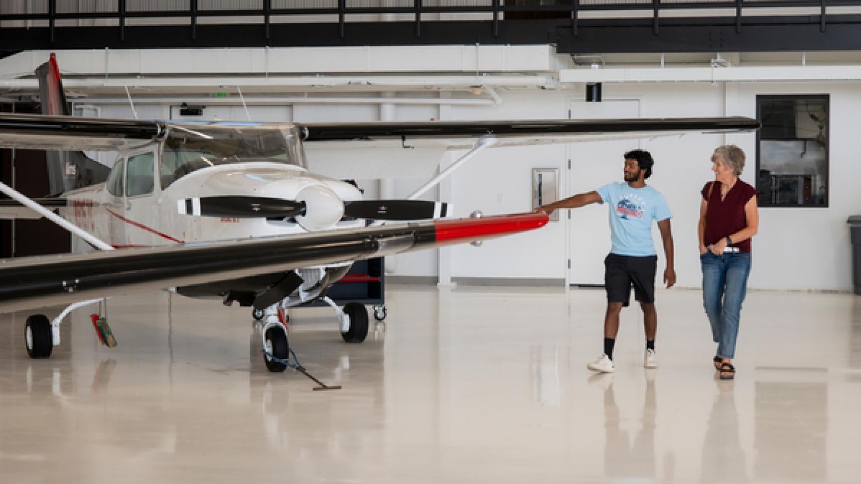 People look at an airplane in the Aircraft Maintenance Training Center