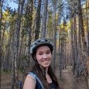 Student Academic Advisor Jessica Runchey picture with trees with bike helmet