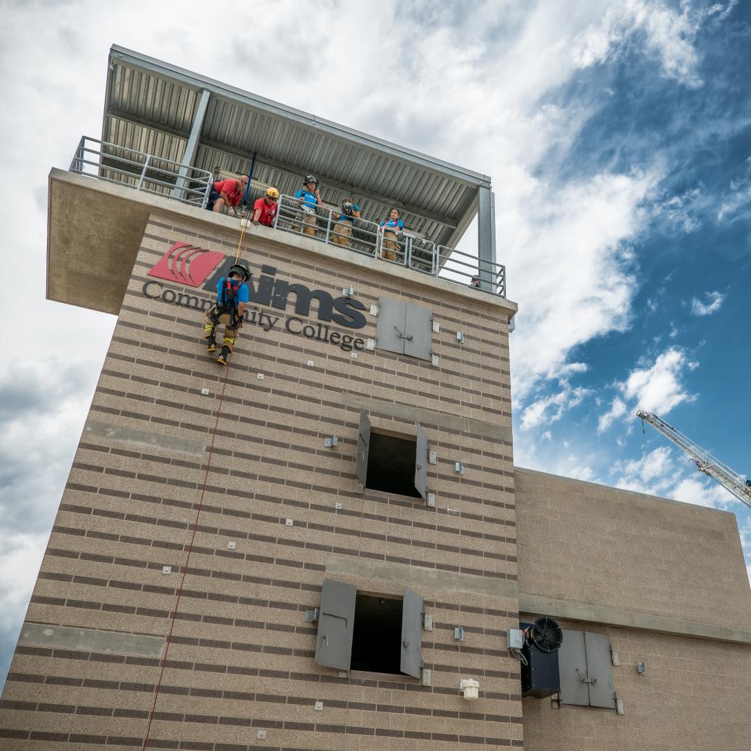 Student rappling from burn tower at Aims