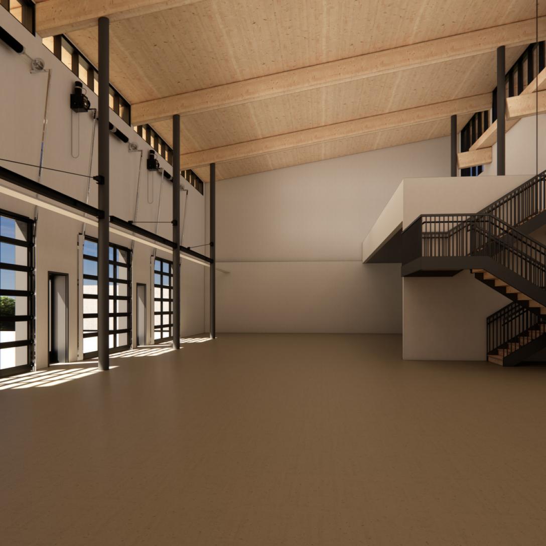 An interior rendering of a vast, high-ceilinged industrial workspace. The room features smooth concrete floors, massive glass garage doors lining the left wall, a metal staircase on the right leading up to a mezzanine, and a light wood ceiling supported by tall, dark steel columns.