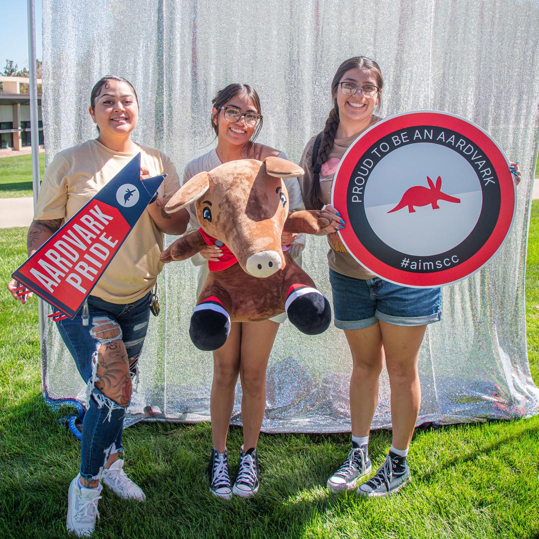 Aims Student at photo booth with Arty plush