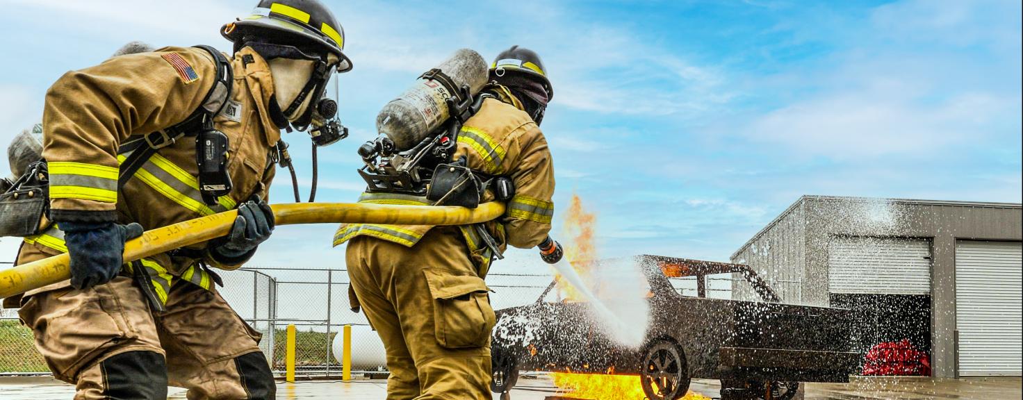 Aims Community College Fire Science students extinguishing a vehicle fire.