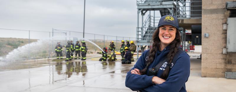 A woman wearing firefighter gear at the 2024 Women in Fire event at Aims