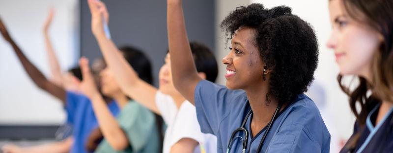 Aims allied health students raising their hands in class