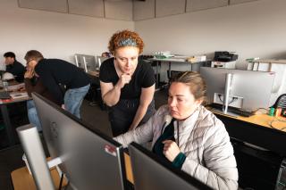 A student and instructor working at a computer