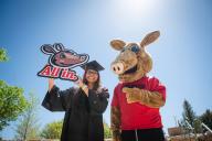 Arty and student in cap in gown with "All in" sign