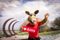 Arty the Aardvark Mascot at the Aims Greeley campus holding a sight that says I love Aims