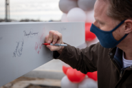 Masked person signing beam