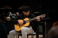 student playing an acoustic guitar