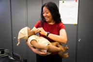Early Childhood Education Student holds robotic infant at puts pacifier in its mouth