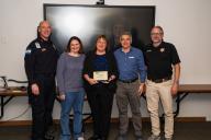 five people standing with award