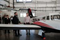 Hickenlooper and Aims staff looks at airplane in hanger