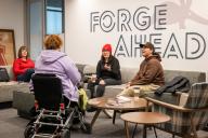 Students at the Student Commons Lobby with Forge Ahead art on the wall