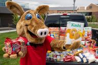 Arty Mascot posing with food donations in a truck