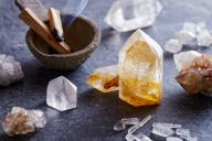 crystals on a table next to a small bowl with burning palo santo wood incense