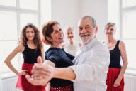 A middle-aged couple dancing while two teachers and another student look on