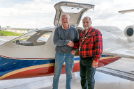 Two men standing by an airplane