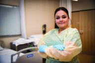 Aims CNA student in hosptial room with rubber gloves