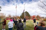 People watching a USA and Colorado Flag being raised