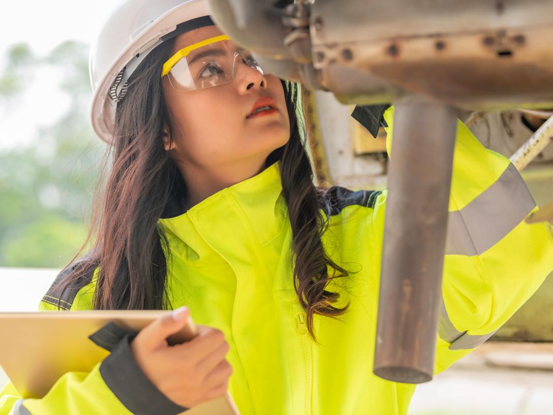 woman in hardhat inspecting aircraft