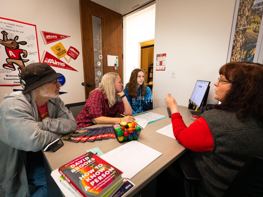 A family of three sits across the desk from an Aims advisor and she talks about Aims different options and majors.