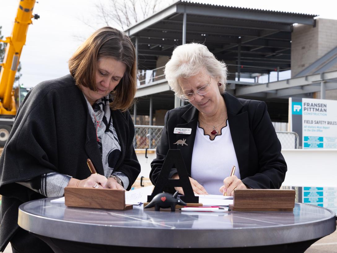 Mitzi Moran & Dr. Leah L. Bornstein sign documents 