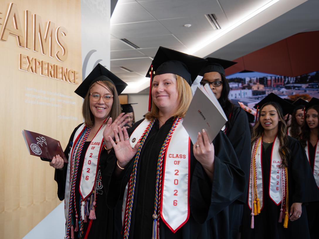 students walking into graduation in caps and gowns